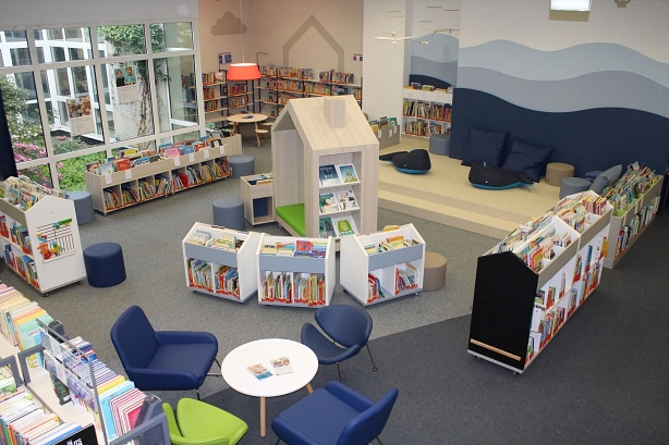 Blick von oben in die Kinderabteilung mit Bücherregalen und Sitzgelegenheiten © Stadtbibliothek